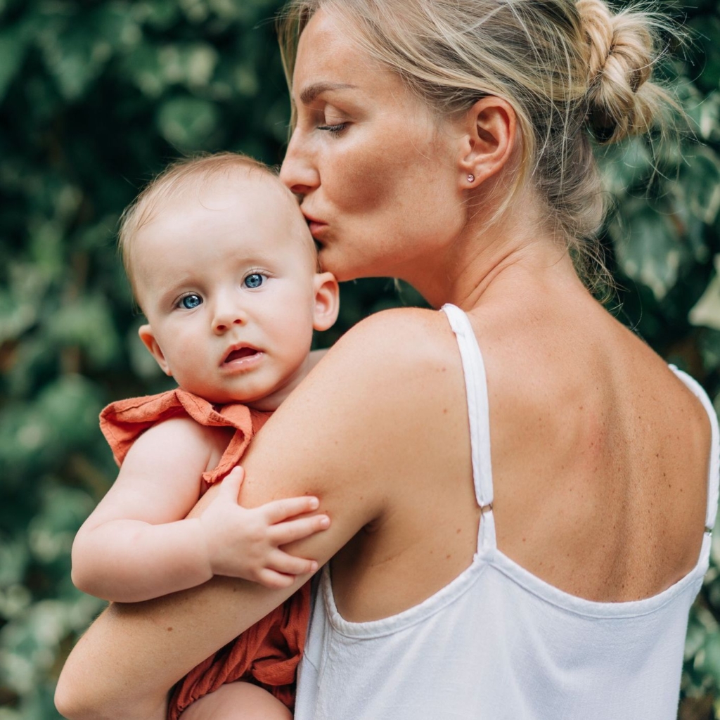 Mother holding new baby on her shoulder